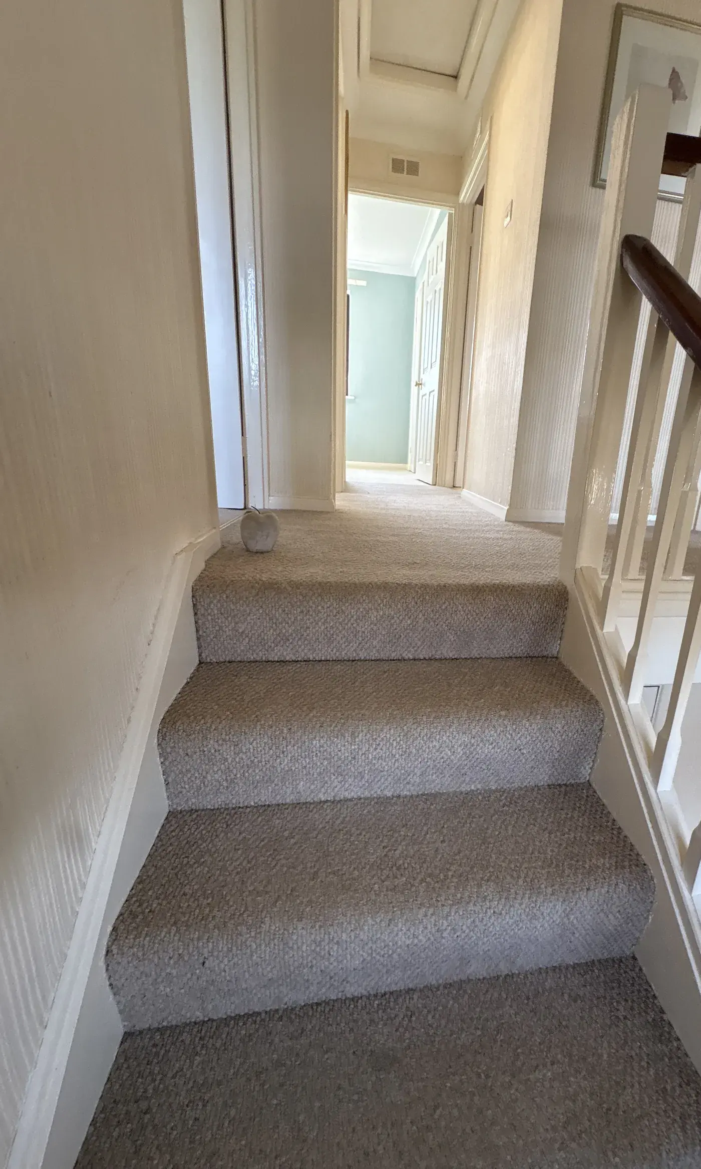 Beige carpeted stairs and landing in a home, freshly vacuumed and free of marks